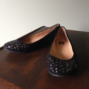 Black round toe flat with nickel finish studs.